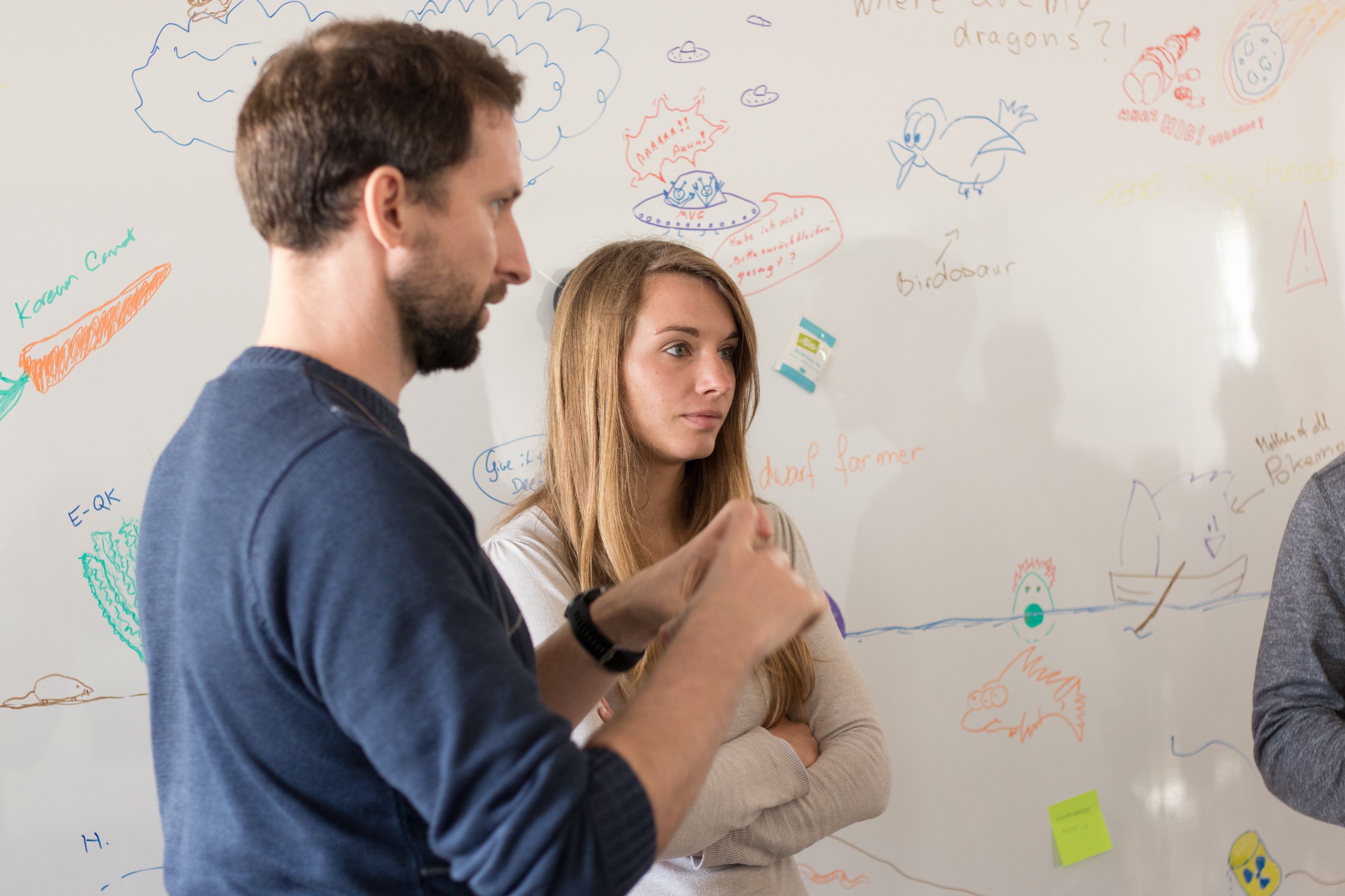 People discussing around whiteboard